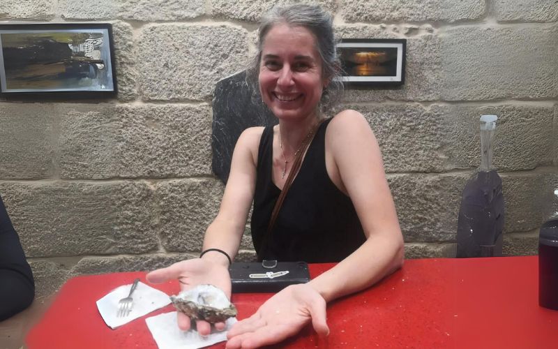 Buitenlandse toeristen vinden een parel in een oester in een restaurant in Galicië
