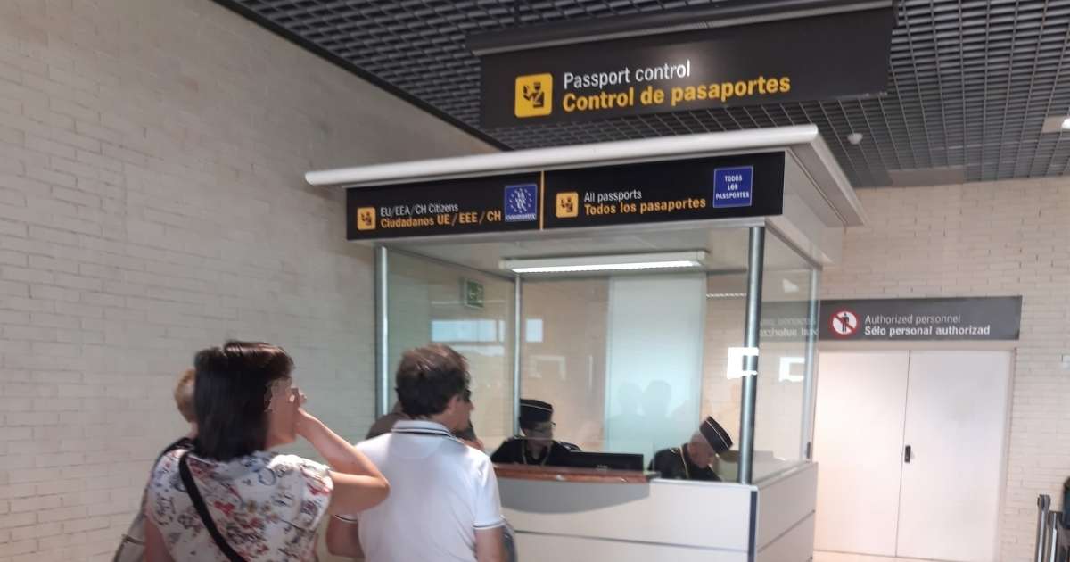 Reizigers bij de paspoortcontrole op een Spaanse luchthaven, met loketten voor EU-burgers en alle paspoorten