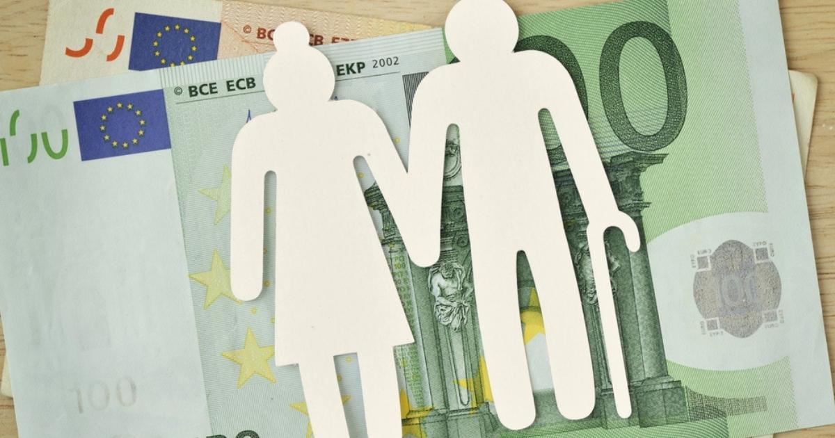 Uitgeknipte figuren van een ouder echtpaar op een stapel eurobiljetten, symbool voor pensioen en financiën