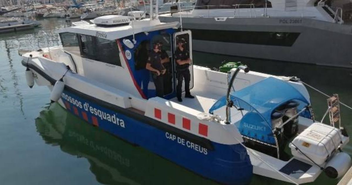 Politieboot van de Mossos d'Esquadra met de naam Cap de Creus, met twee agenten aan boord, aangemeerd in een jachthaven